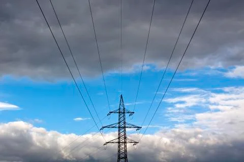 Power supply tower in front of some impressive cloudy sky Stock Photos