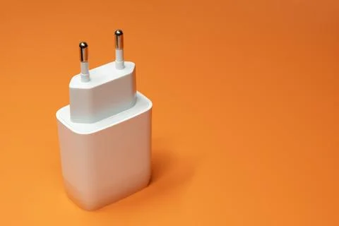 Power supply without cable on orange. Power adapter, gadget charger Stock-Fotos