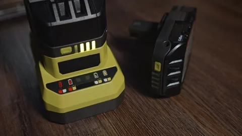 Power tool charger with battery and light level indicators on floor Stock Footage 333960722