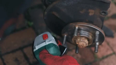 Power tool removing rust from car wheel hub with abrasive disc during repair Vídeos de archivo 341568843