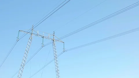 Power Tower with electrical cables against a blue clear sky on a sunny day (4K) Stock Footage 97463246