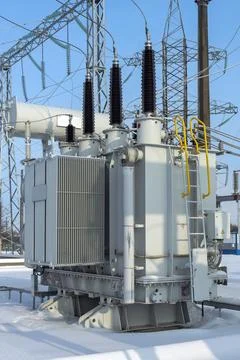 Power transformer in a high-voltage electrical substation outdoors in winter. Stock Photos