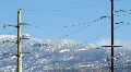 Power transmission and snowy mountains - 4 pan right HD Footage