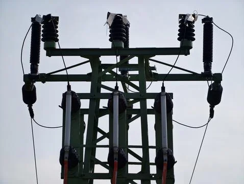 Power transmission structure with ceramic insulators against moody overcast.. Fotos Stock