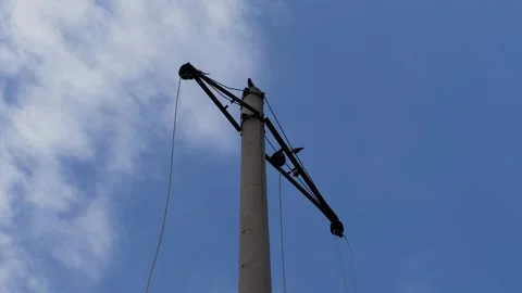 A power transmission tower stands in a forest against a blue sky Stock Footage 306169127