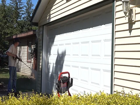 Power washing garage from winters dirt and grime Stock Footage