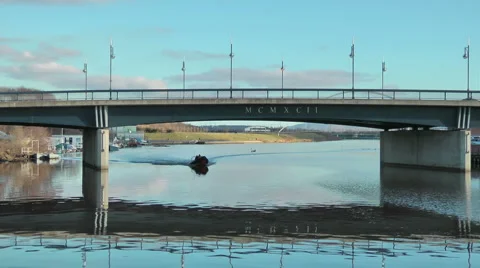 Powered dingy sails from boat yard on urban river Stock-Footage 1064855