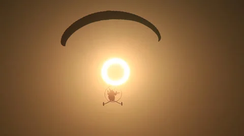 Powered Paraglider flying the Annular Solar Eclipse Stock Footage 26586420