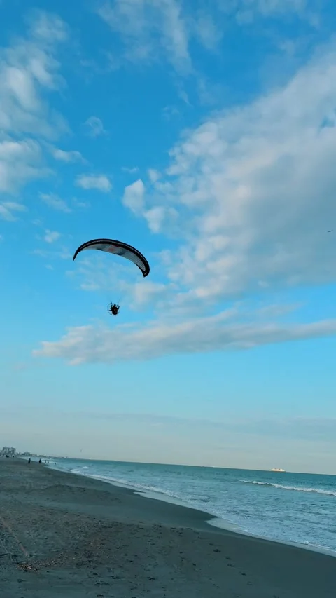 Powered paraglider flying over the ocean at Cocoa Beach Stock Footage 332167260
