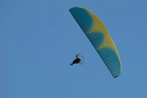 Powered paraglider pilot during the flight in blue sky Fotos de archivo