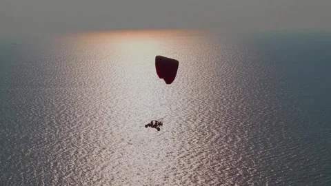 Powered Paraglider Soaring Above the Ocean Shoreline (Sunset). Stock Footage 323943255