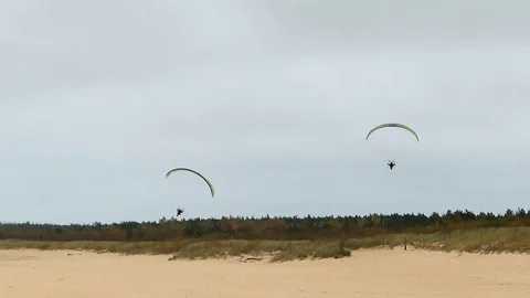 Powered Paragliders Flying Extremely Low Over Sandy Sea Beach Stock Footage 98772973