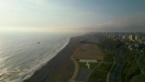 Powered paragliding flight over the pacific coast Stockbeeldmateriaal 296990749