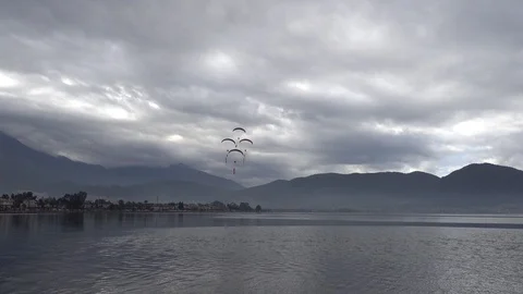Powered paragliding machines are approaching in the cloudy sky Stock-Footage 86886939