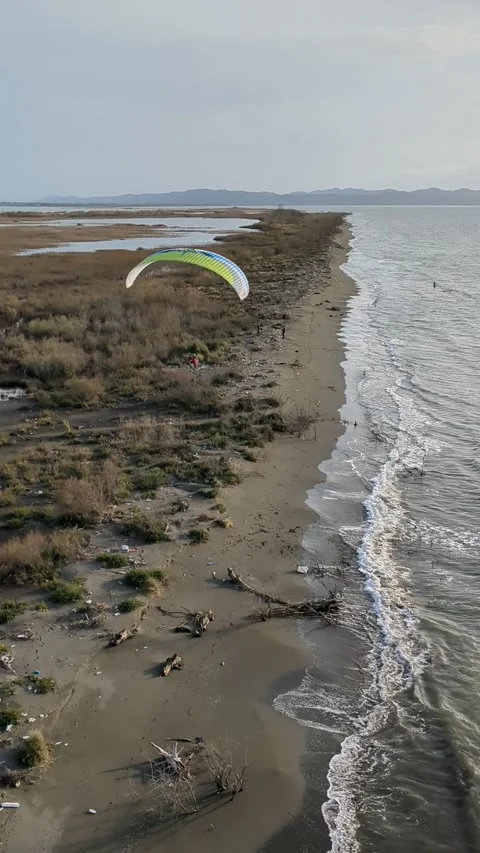Powered paragliding paramotor flying over Albanian coast mountains and beaches Video stock 317487961
