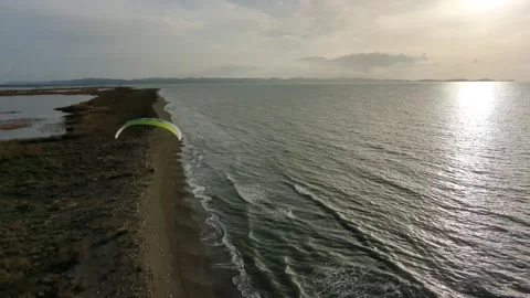 Powered paragliding paramotor flying over Albanian coast mountains and beaches Stockbeeldmateriaal 317488038