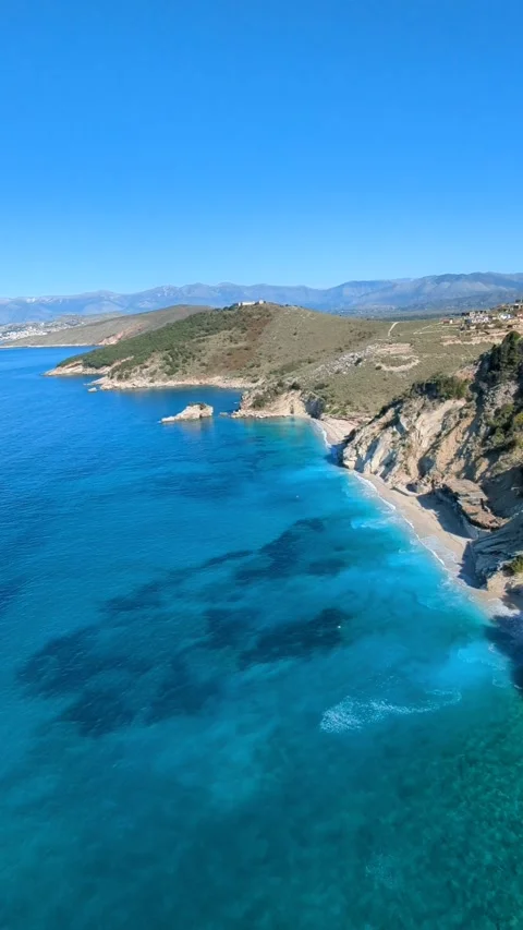 Powered paragliding paramotor flying over Albanian coast mountains and beaches Stockbeeldmateriaal 317488158