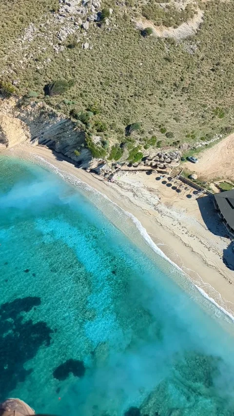 Powered paragliding paramotor flying over Albanian coast mountains and beaches Stockbeeldmateriaal 317488172