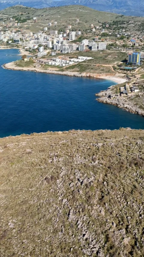 Powered paragliding paramotor flying over Albanian coast mountains and beaches Stockbeeldmateriaal 317488274