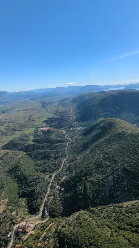 Powered paragliding paramotor flying over Albanian coast mountains and beaches Stockbeeldmateriaal 317488426
