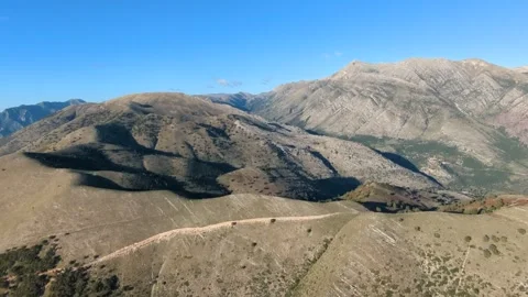 Powered paragliding paramotor flying over Albanian coast mountains and beaches Stock Footage 317488544