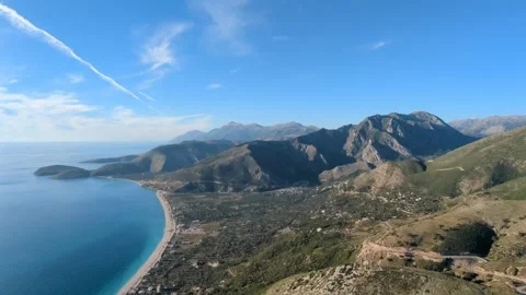 Powered paragliding paramotor flying over Albanian coast mountains and beaches Stock Footage 317488830