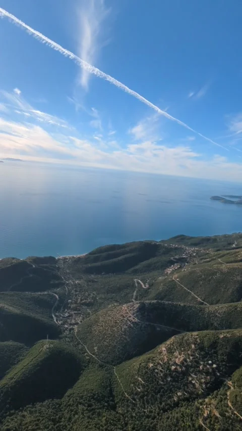 Powered paragliding paramotor flying over Albanian coast mountains and beaches Stock Footage 317488917