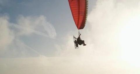 Powered Paragliding PPG pilot wears  back-pack motor flies in front, sunset sky Stock Footage 273503553