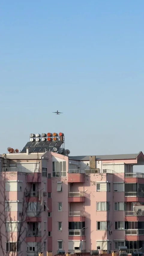 A powerful airplane takes off, soaring dramatically above the rooftops of res Stock Footage 301846971