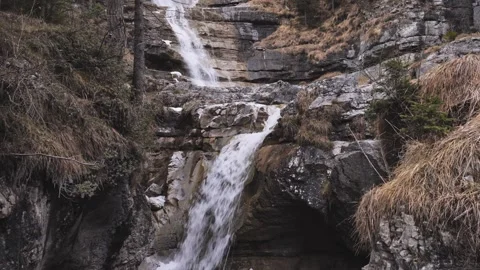A powerful alpine waterfall flowing through a rugged rock Stock Footage 331257545