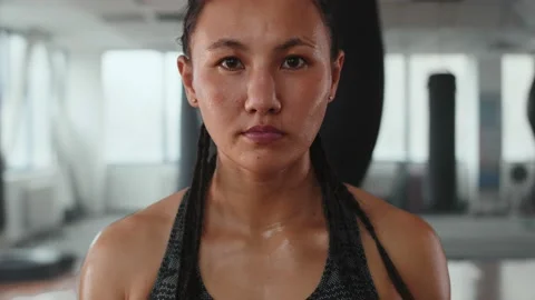 Powerful and Determined, Intense Close-up portrait of Sweaty Asian Girl in the Video stock 237538360