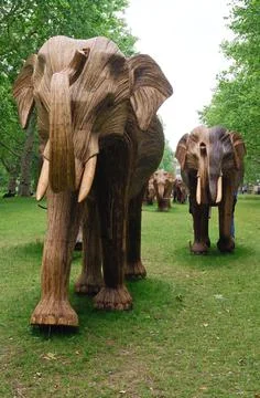 Powerful and dramatic picture of a large herd of elephant SCULPTURES seen head 스톡 사진