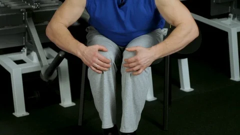 Powerful athlete makes isometric exercise by resisting kneeling with his hands Stock Footage 115251413