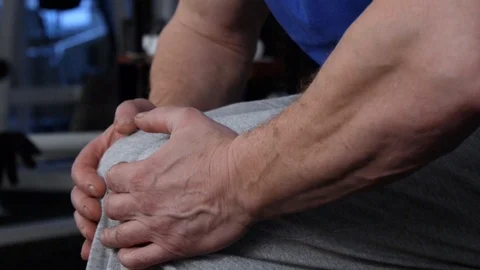 Powerful athlete makes isometric exercise by resisting kneeling with his hands Stock Footage 115251797