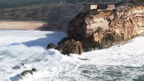 Powerful Atlantic waves explode against Nazaré rocks and cliffs. Aerial drone Stock Footage 327404720