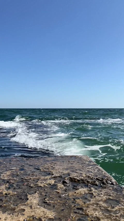 Powerful blue-green waves breaking on coastal breakwater 動画素材 329319806