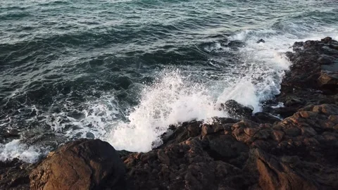 Powerful blue waves rolling and splashing on volcanic rocks Video stock 229148504
