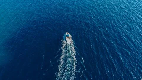 Powerful boat tracing a path of white foam across the vast Stock Photos