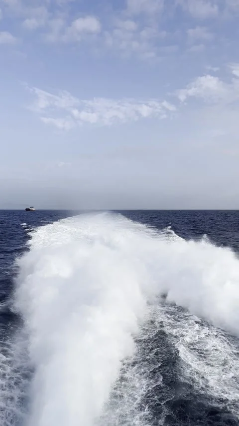 Powerful boat wake and white water foam on deep blue sea ocean vertical 库存影片 344476721