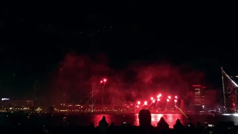 Powerful, bright red fireworks piercing the night sky over the city Stock Footage 312678272