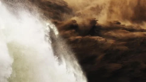 Powerful cascading waterfall splashing into muddy river Video stock 333148977