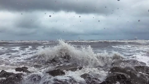 Powerful Caspian Sea waves crash against rocky shore under stormy grey clouds Stock Footage 336245412