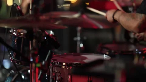 Powerful drum set with tattoos illuminated by stage lighting Stock Footage 323946147