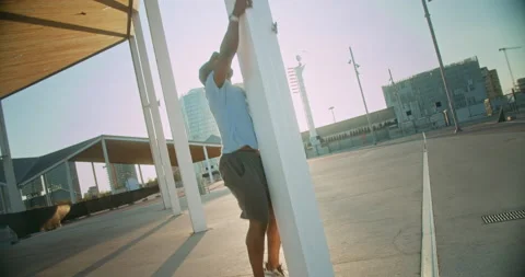 Powerful energetic black guy training climbing pole on modern city street Stock Footage 140738413