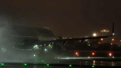 Powerful Engine Water Spray EVA Air Airbus Passenger Airplane Takeoff Rain Night Video stock 257789671