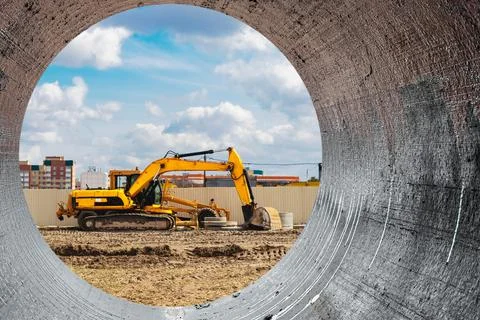 Powerful excavator at the construction site. View of the excavator through th Stock Photos