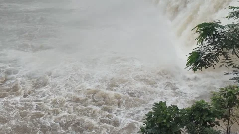 Powerful floodwater rushing through dam gate with heavy turbulence Stock Footage 315569064