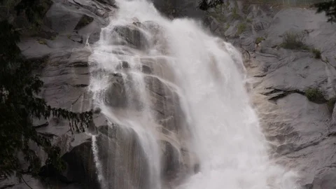 Powerful Flowing Waterfall Cascading Over Dark Brown Rocks Creating Mist Stock Footage 93813340