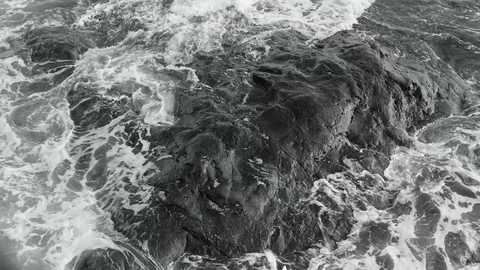 Powerful Foaming Wave Tide Against Surround on Reef Rock in Black and White Tone 스톡 동영상 128946414