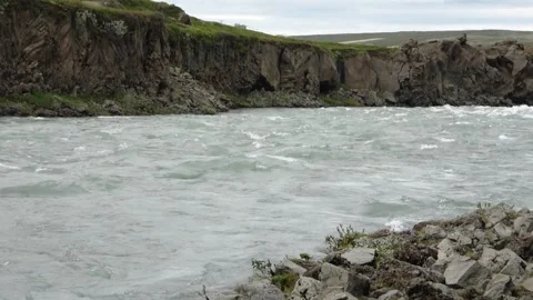 Powerful glacial river current flowing through a rugged basalt rock canyon Stock Footage 346326787